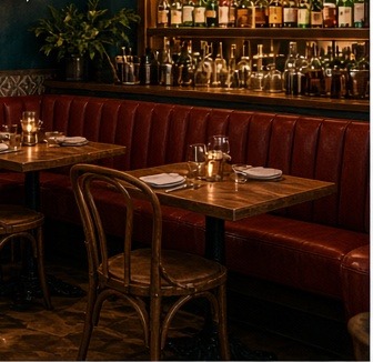 Leather banquette and bentwood chairs in a candlelit dining room