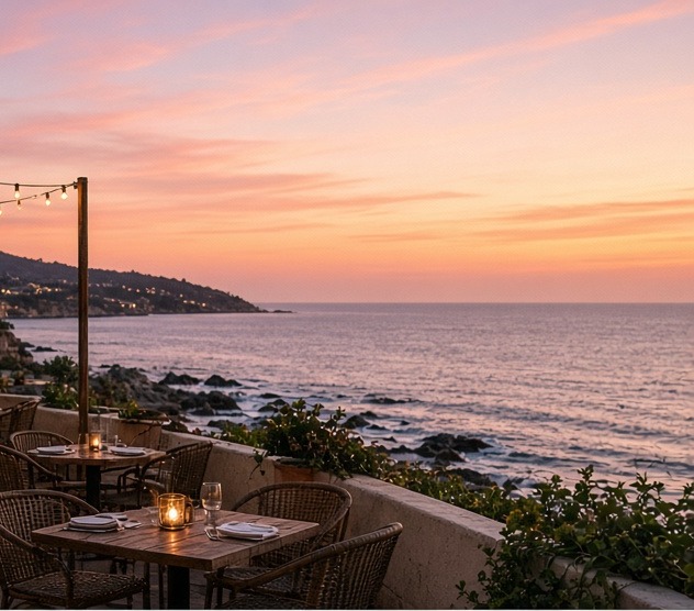 Oceanfront dining terrace at dusk with the Pacific and headland beyond
