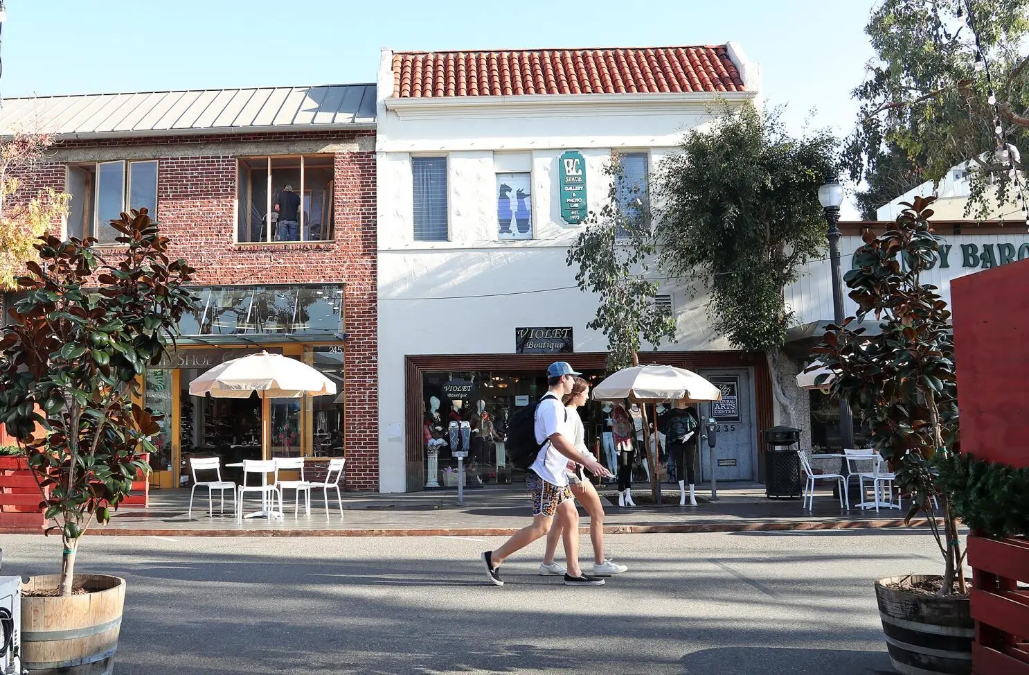Downtown Laguna storefronts with patio umbrellas and pedestrians on a bright afternoon