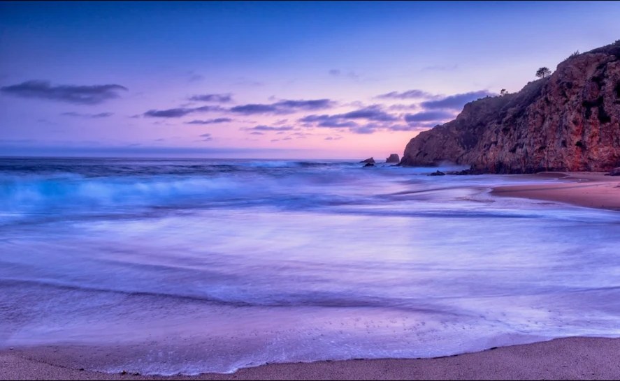 Long exposure of surf at blue hour beneath Laguna cliffs